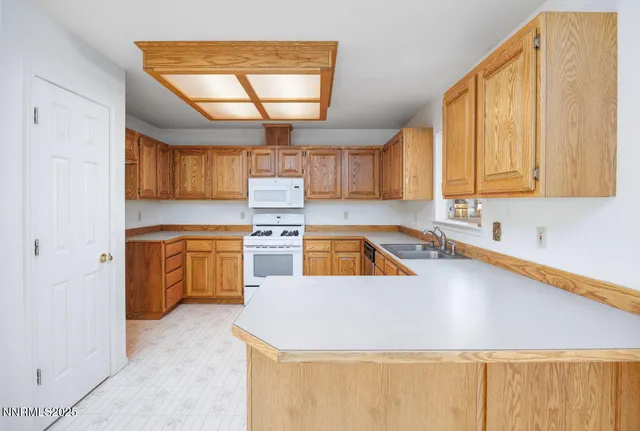 a kitchen that has a sink a stove and cabinets