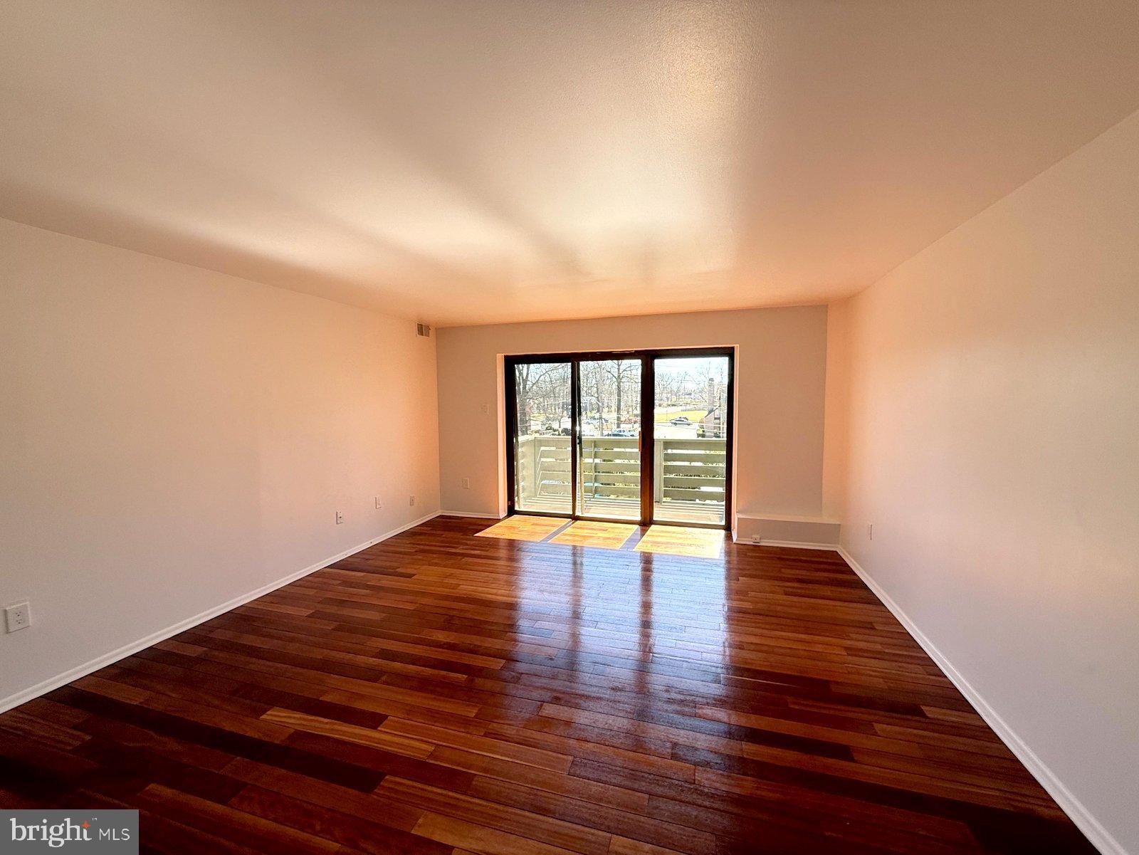 606 Cooper Landing Road, Unit A3K Cherry Hill, NJ 08002 - Photo 2 of 17 a view of an empty room with wooden floor and window
