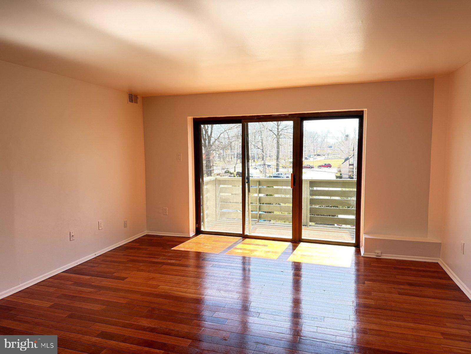 606 Cooper Landing Road, Unit A3K Cherry Hill, NJ 08002 - Photo 3 of 17 a view of an empty room with wooden floor and a window