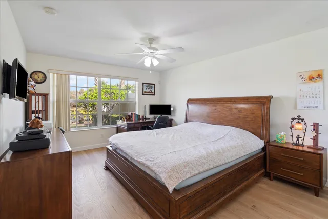 a large bedroom with bed and wooden floor