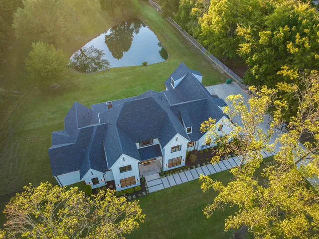 an aerial view of a house with a garden and lake view