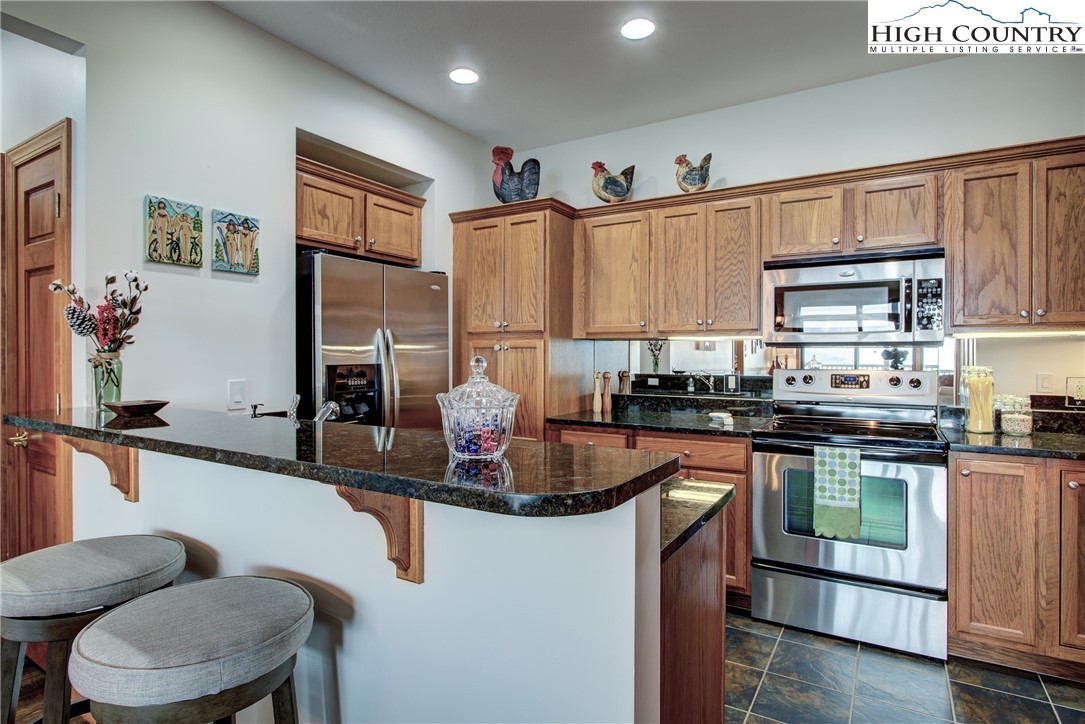 202 Pleasant View, Unit 9D Sugar Mountain, NC 28604 - Photo 23 of 48 a kitchen with stainless steel appliances granite countertop a sink a stove and a refrigerator