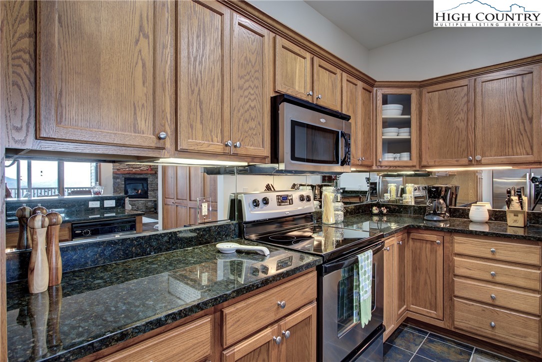 202 Pleasant View, Unit 9D Sugar Mountain, NC 28604 - Photo 25 of 48 a kitchen with stainless steel appliances granite countertop a stove a sink dishwasher and a microwave oven on the granite countertops
