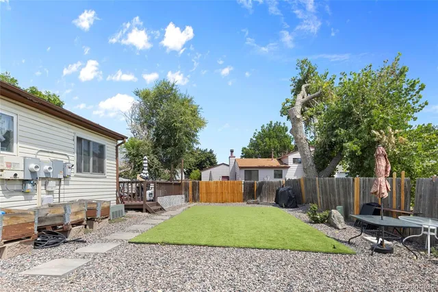 a backyard of a house with table and chairs