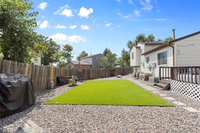 a view of a backyard with a garden and deck