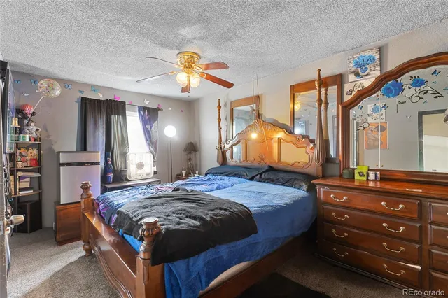 a bedroom with a bed and a mirror on the dresser