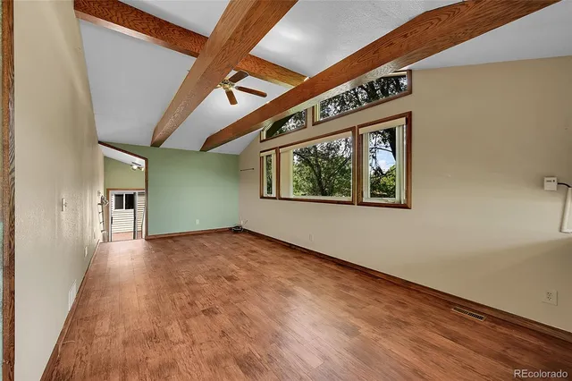 a living room with furniture a flat screen tv and a floor to ceiling window