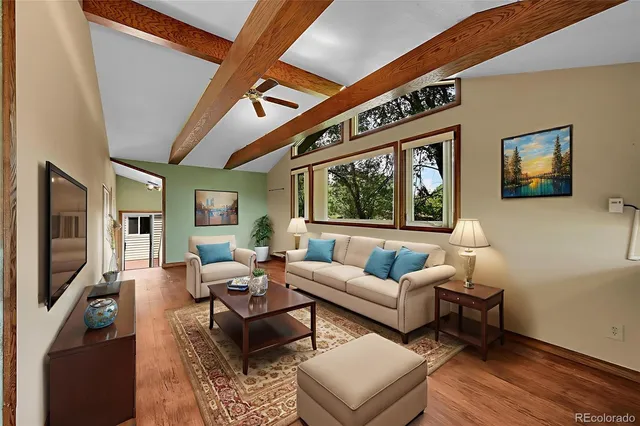 a view of an empty room with wooden floor and stairs