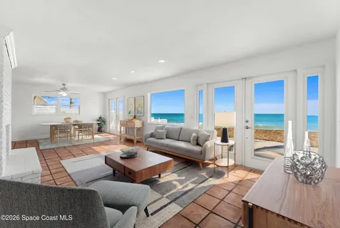 a view of an empty room with window and chandelier fan