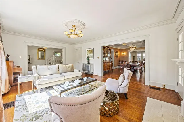 a living room with furniture a dining table and a chandelier