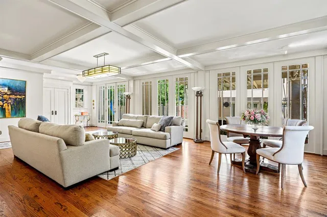 a living room with furniture wooden floor and large windows
