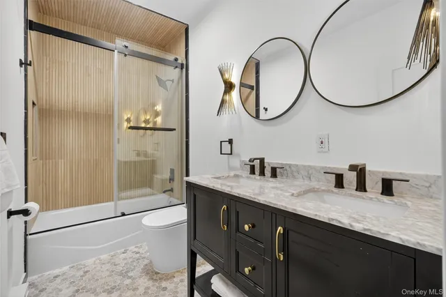 a bathroom with a granite countertop sink a mirror and a shower