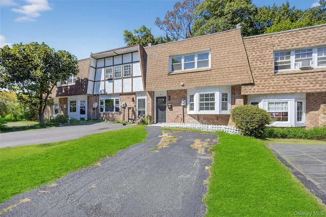 a front view of a house with a yard and trees