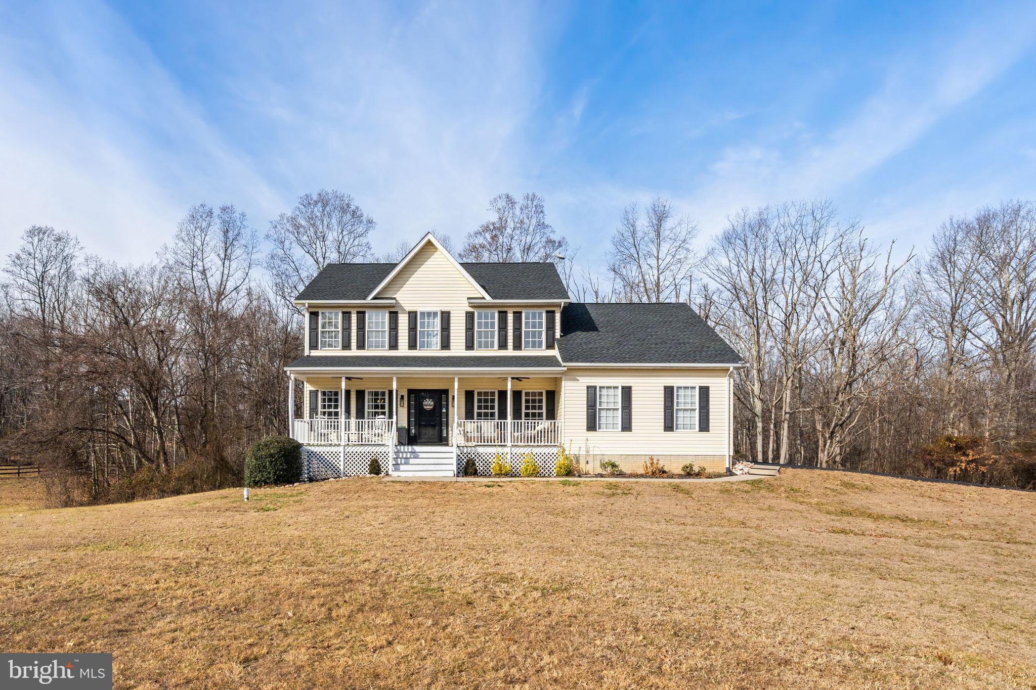 a front view of a house with a yard and trees