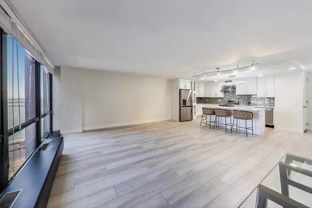 a kitchen with stainless steel appliances wooden floor and large windows
