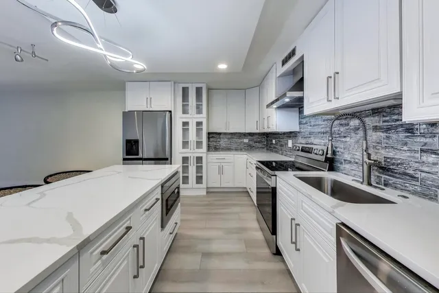 a kitchen with a stove sink and cabinets