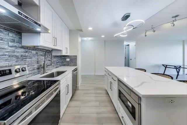 a kitchen with stainless steel appliances white cabinets and a sink
