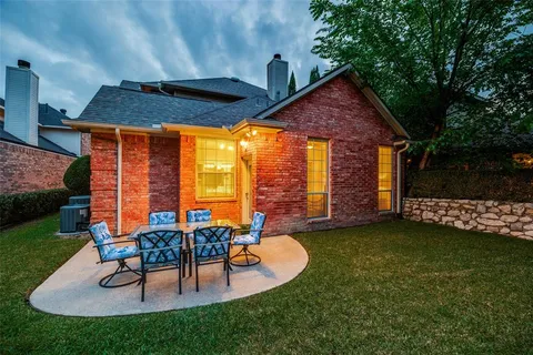 a backyard of a house with table and chairs