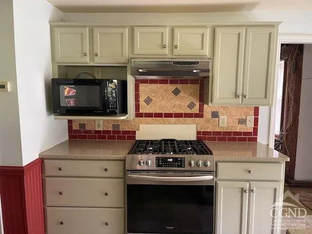 a kitchen with stainless steel appliances granite countertop a stove and a microwave