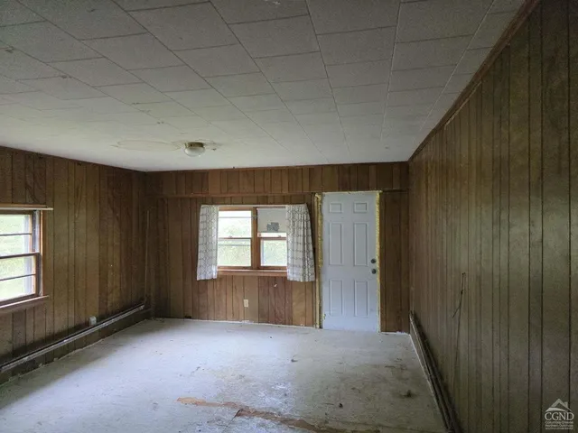 an empty room with windows and cabinet