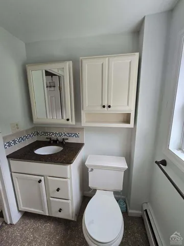 a bathroom with a toilet sink and mirror