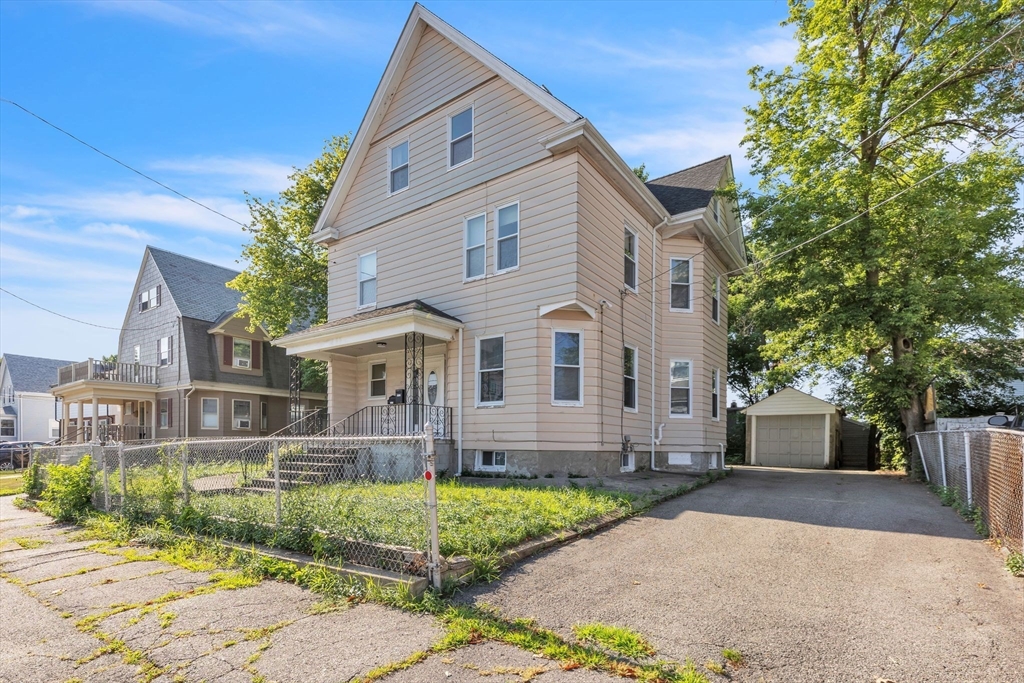 49 Laurel Street Watertown, MA 02472 - Photo 1 of 42 a view of a white house with large windows and a small yard