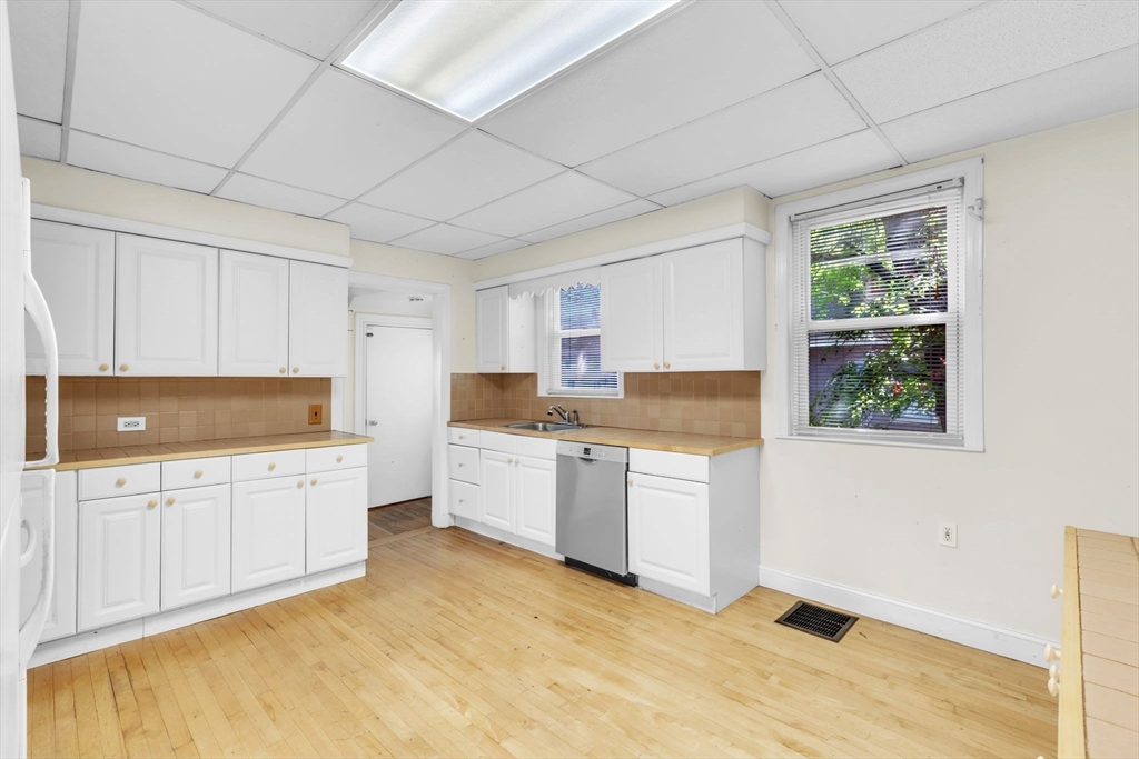 49 Laurel Street Watertown, MA 02472 - Photo 14 of 42 a kitchen with granite countertop a stove a sink and a refrigerator