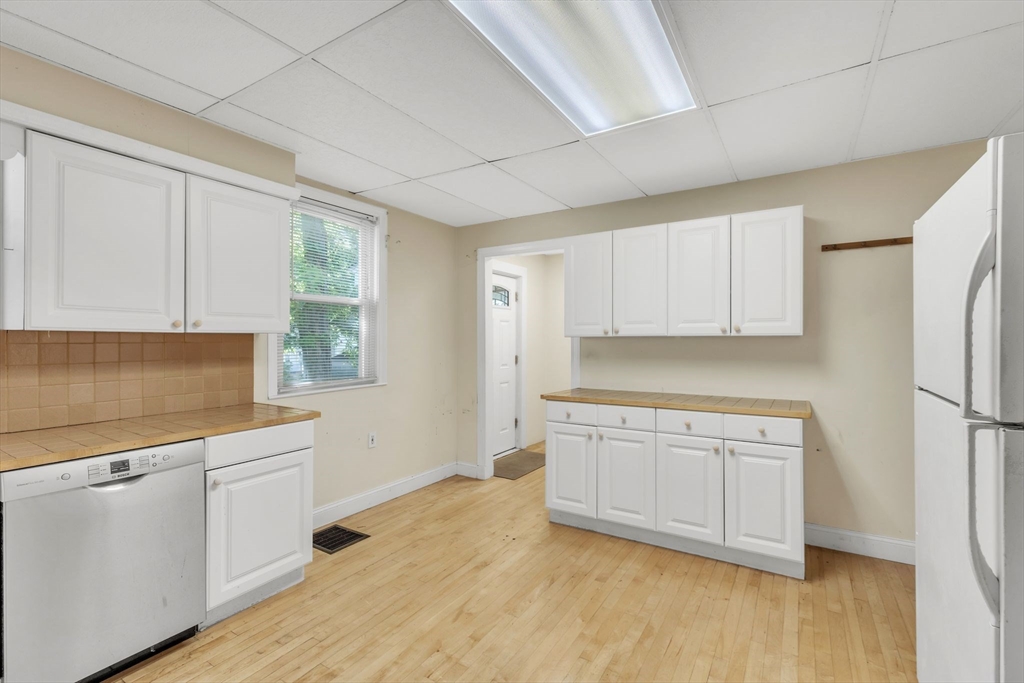49 Laurel Street Watertown, MA 02472 - Photo 17 of 42 a kitchen with white cabinets and white appliances