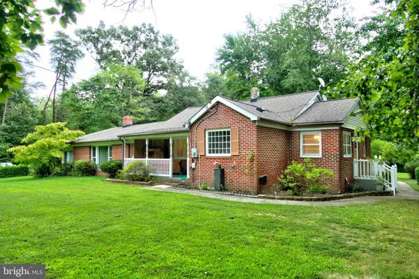 a front view of a house with a yard and green space