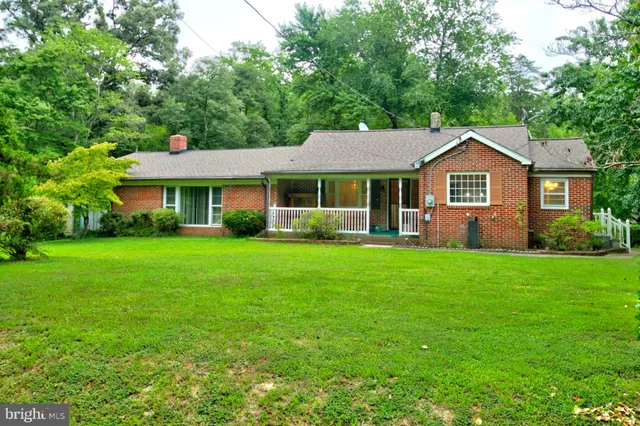 a front view of a house with a yard and green space