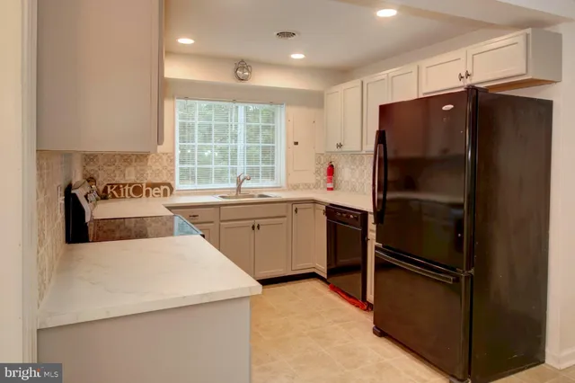 a kitchen with a refrigerator a sink and cabinets