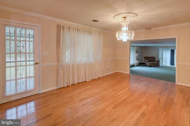 a view of a livingroom with a furniture wooden floor and chandelier