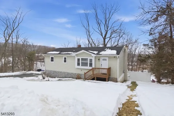 a front view of a house with a yard covered with snow
