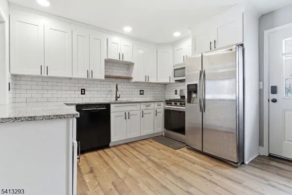 a kitchen with a refrigerator sink and cabinets
