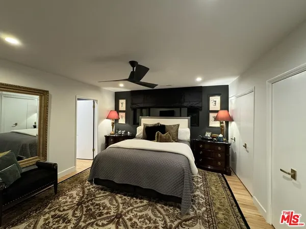 a bedroom with a bed and a mirror on the dresser