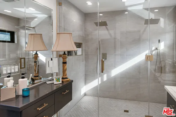 a bathroom with a double vanity sink a mirror and a shower