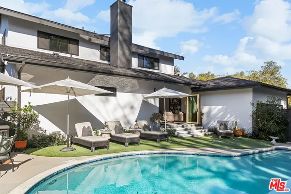 a view of a house with backyard and sitting area