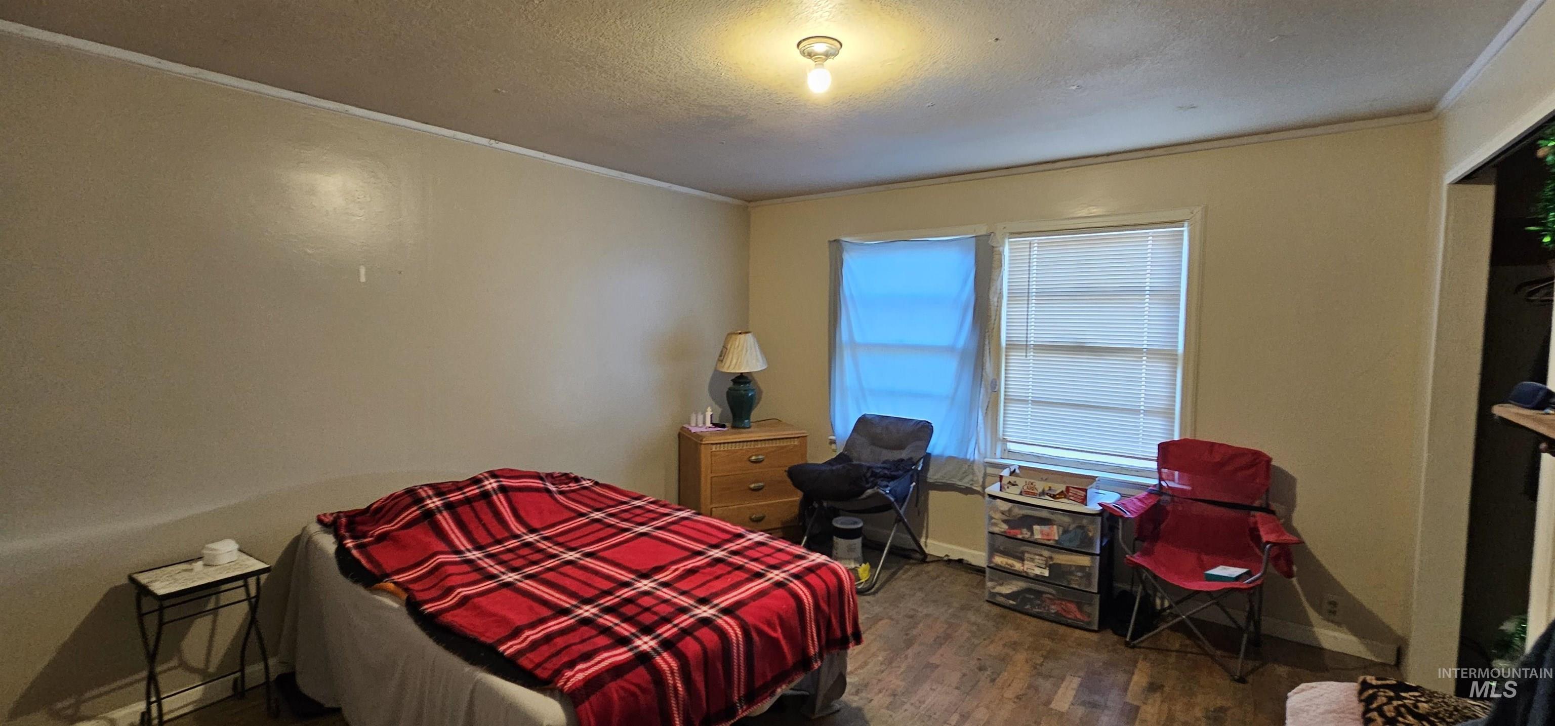 555 15th Street Vale, OR 97918 - Photo 12 of 27 Bedroom with dark wood-style floors, crown molding, and a textured ceiling