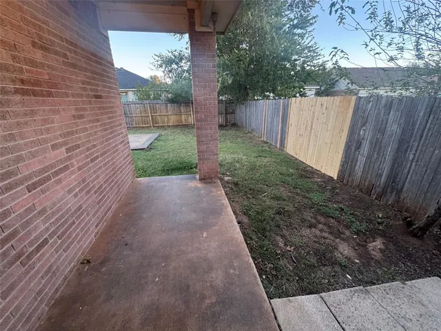 a view of a backyard with wooden fence