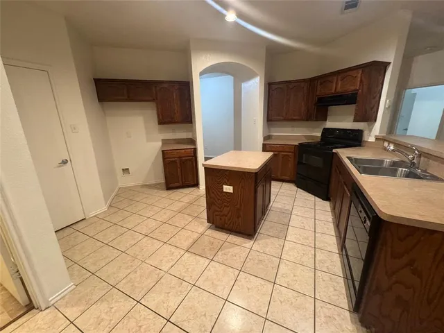 a kitchen with stainless steel appliances a sink a stove a refrigerator cabinets and a counter top space