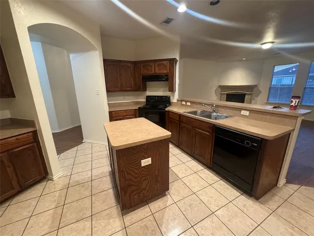 a kitchen with a stove sink and cabinets