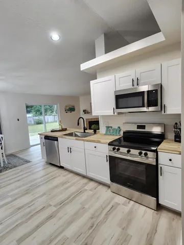 a kitchen with stainless steel appliances a refrigerator sink and cabinets