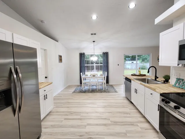 a large kitchen with stainless steel appliances lots of counter space and wooden floor