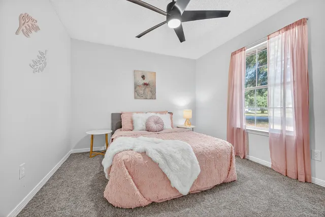 a bedroom with a bed and a chandelier fan