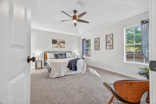 a bedroom with a bed and a painting on the wall