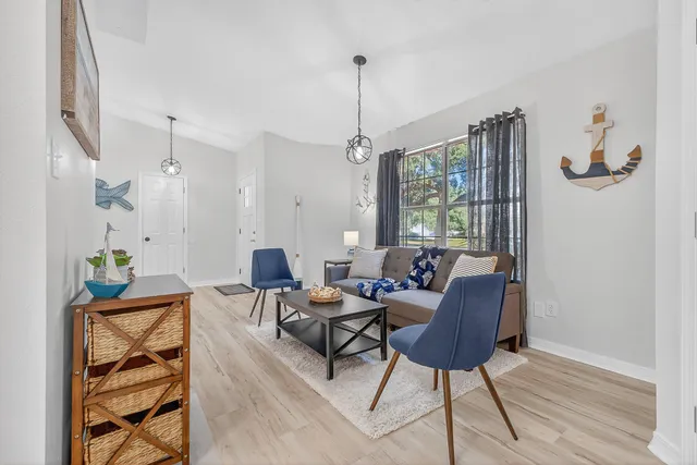 a living room with furniture a window and a chandelier