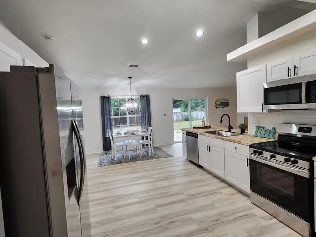 a kitchen with stainless steel appliances kitchen island granite countertop a stove a sink and a microwave