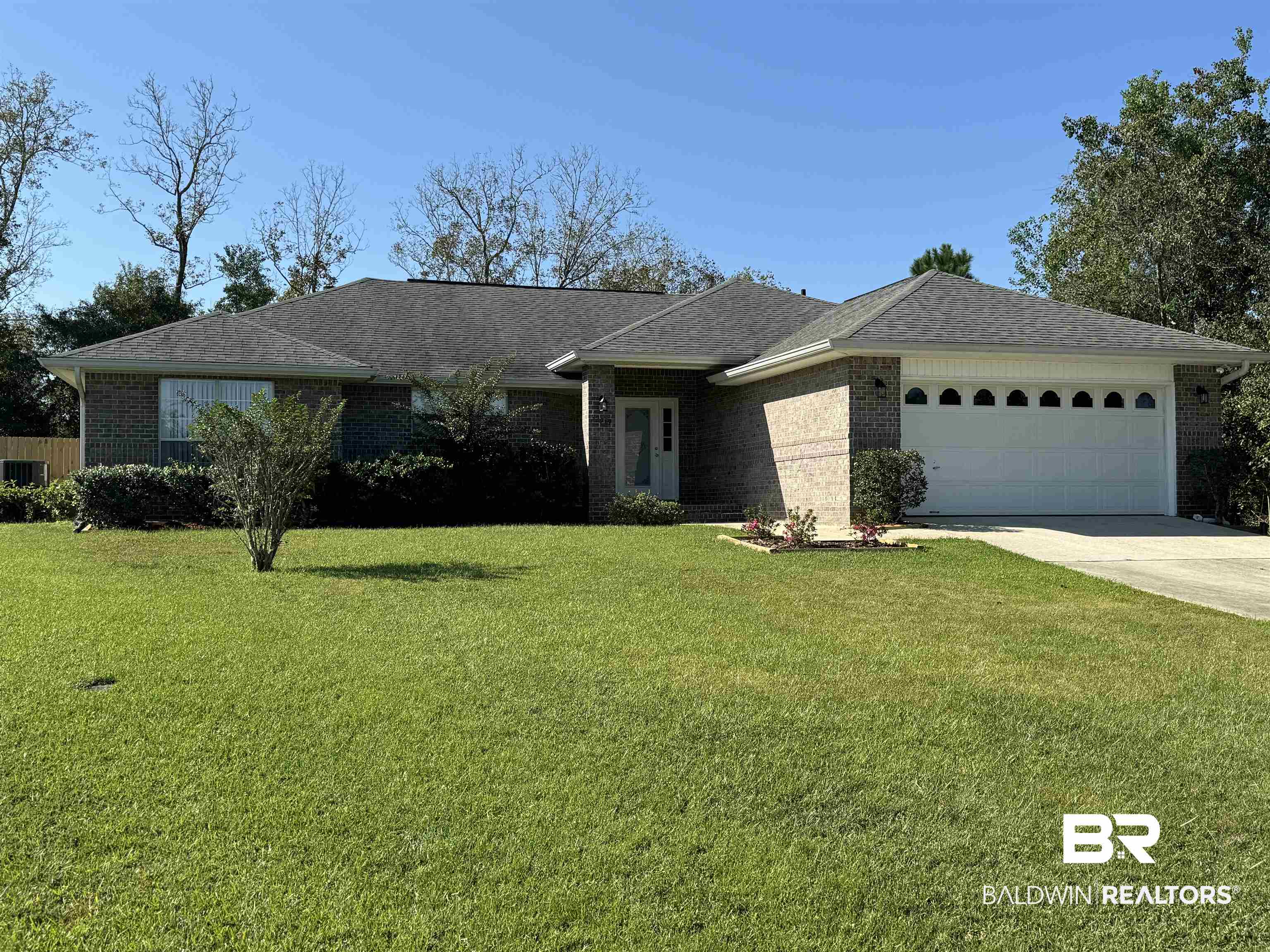 Ranch-style home with a front yard and a garage