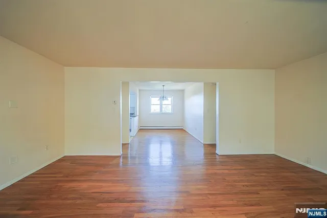 a view of empty room with window and wooden floor
