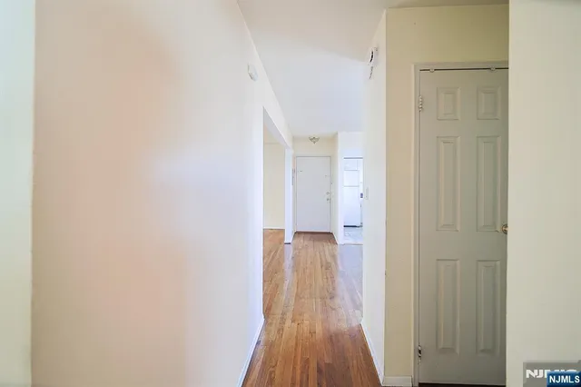 a view of a room with wooden floor and a bathroom